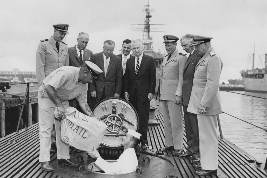 Postmaster General Authur E. Summerfield, fourth from left, looks on as mail is loaded into the USS Barbero in Norfolk, VA, on June 8, 1959.